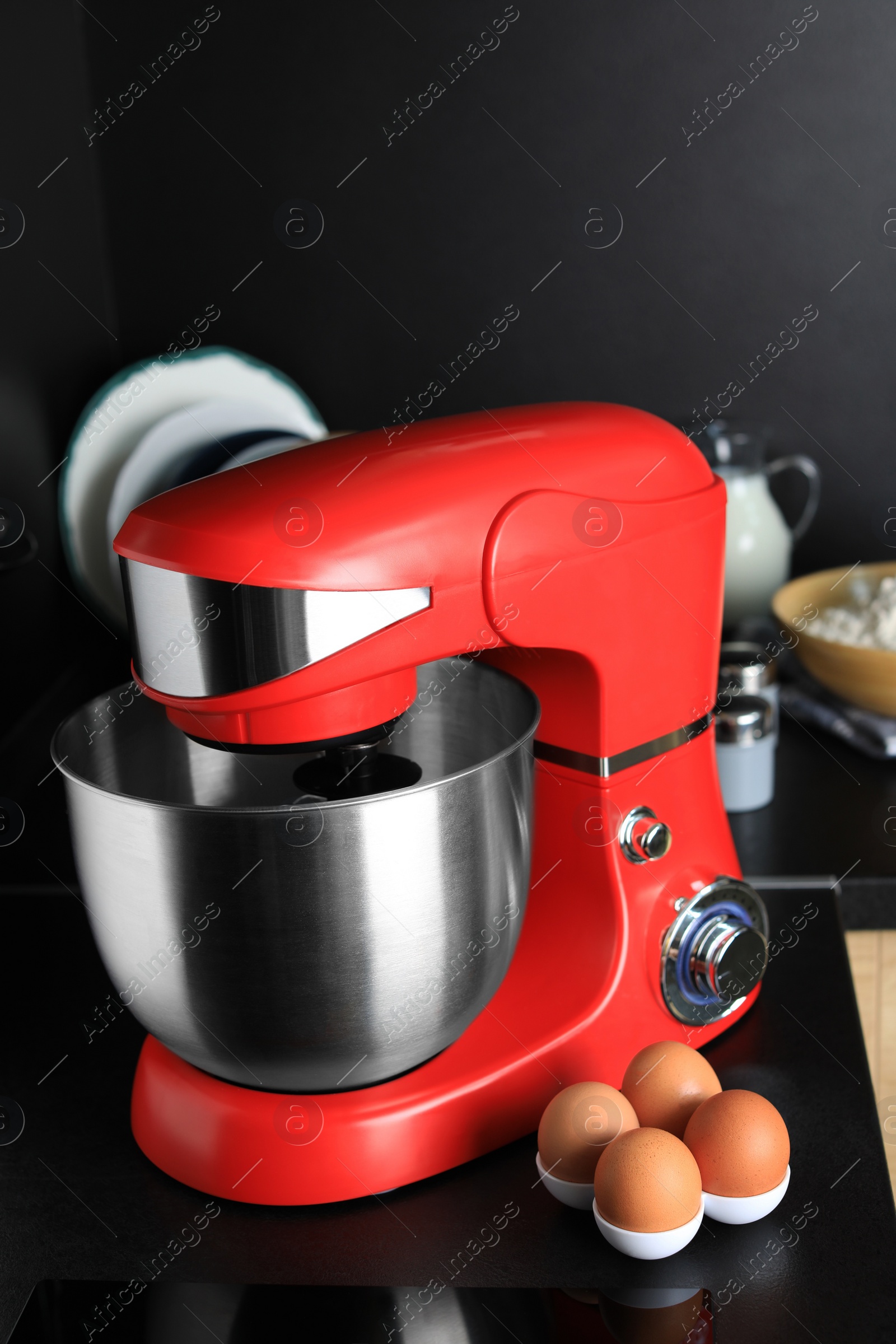 Photo of Eggs near modern stand mixer on countertop in kitchen