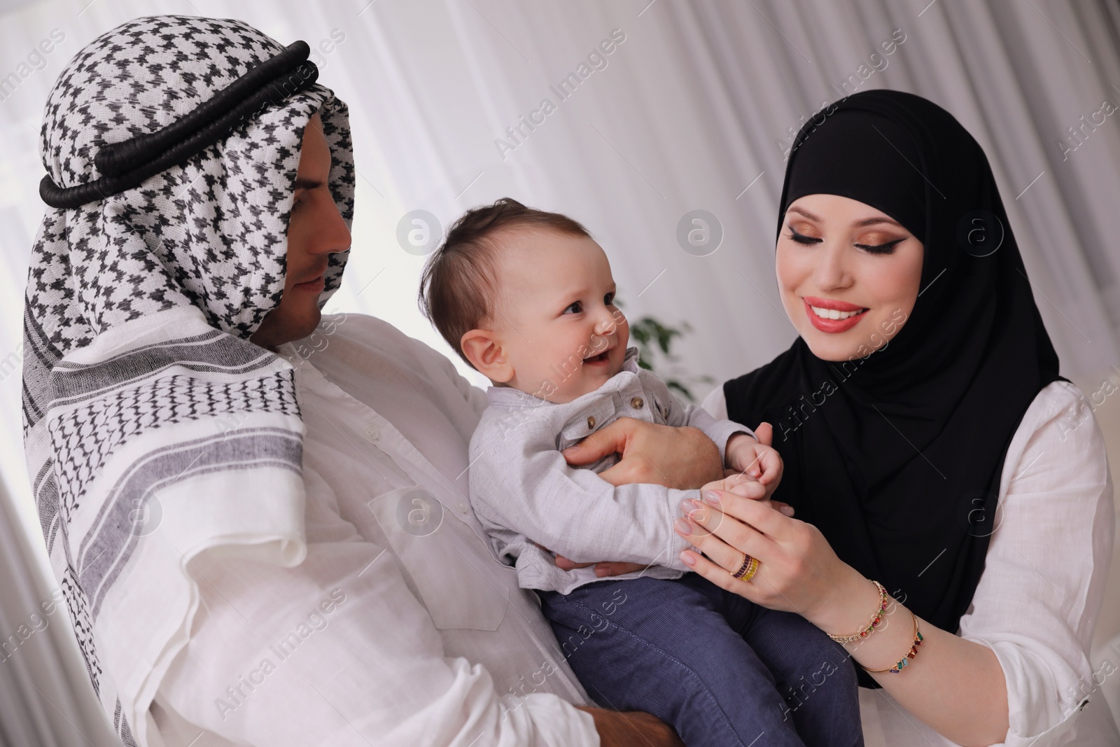 Photo of Happy Muslim family with little son indoors