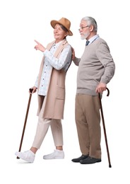 Photo of Senior man and woman with walking canes looking at something on white background