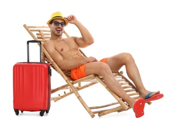 Photo of Young man with suitcase on sun lounger against white background. Beach accessories