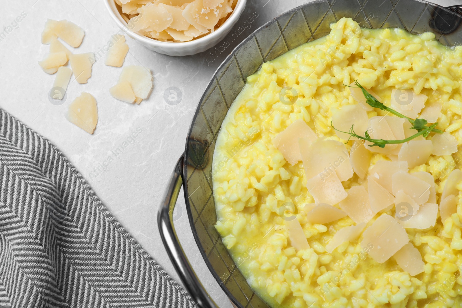 Photo of Delicious risotto with cheese on grey marble table, flat lay