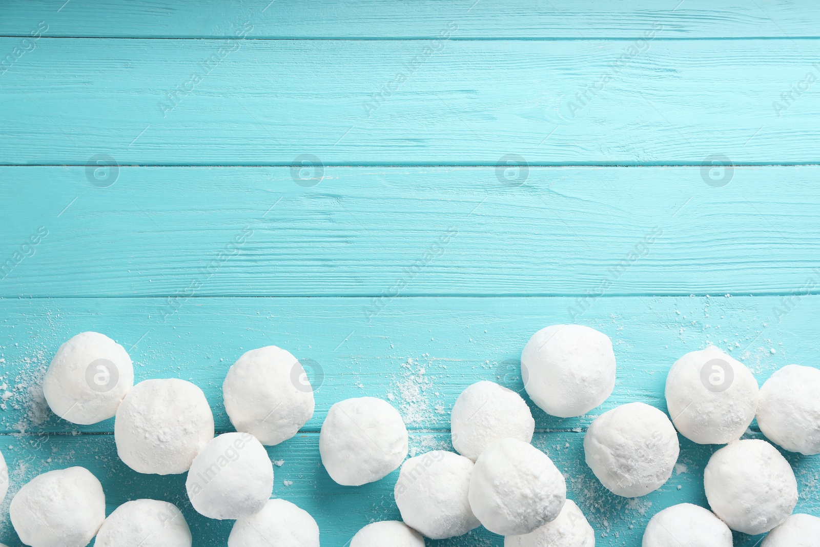 Photo of Snowballs on light blue wooden background, flat lay. Space for text