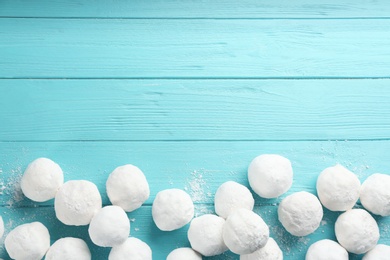 Snowballs on light blue wooden background, flat lay. Space for text