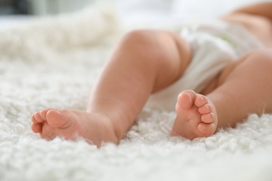 Photo of Cute little baby lying on bed, closeup of legs