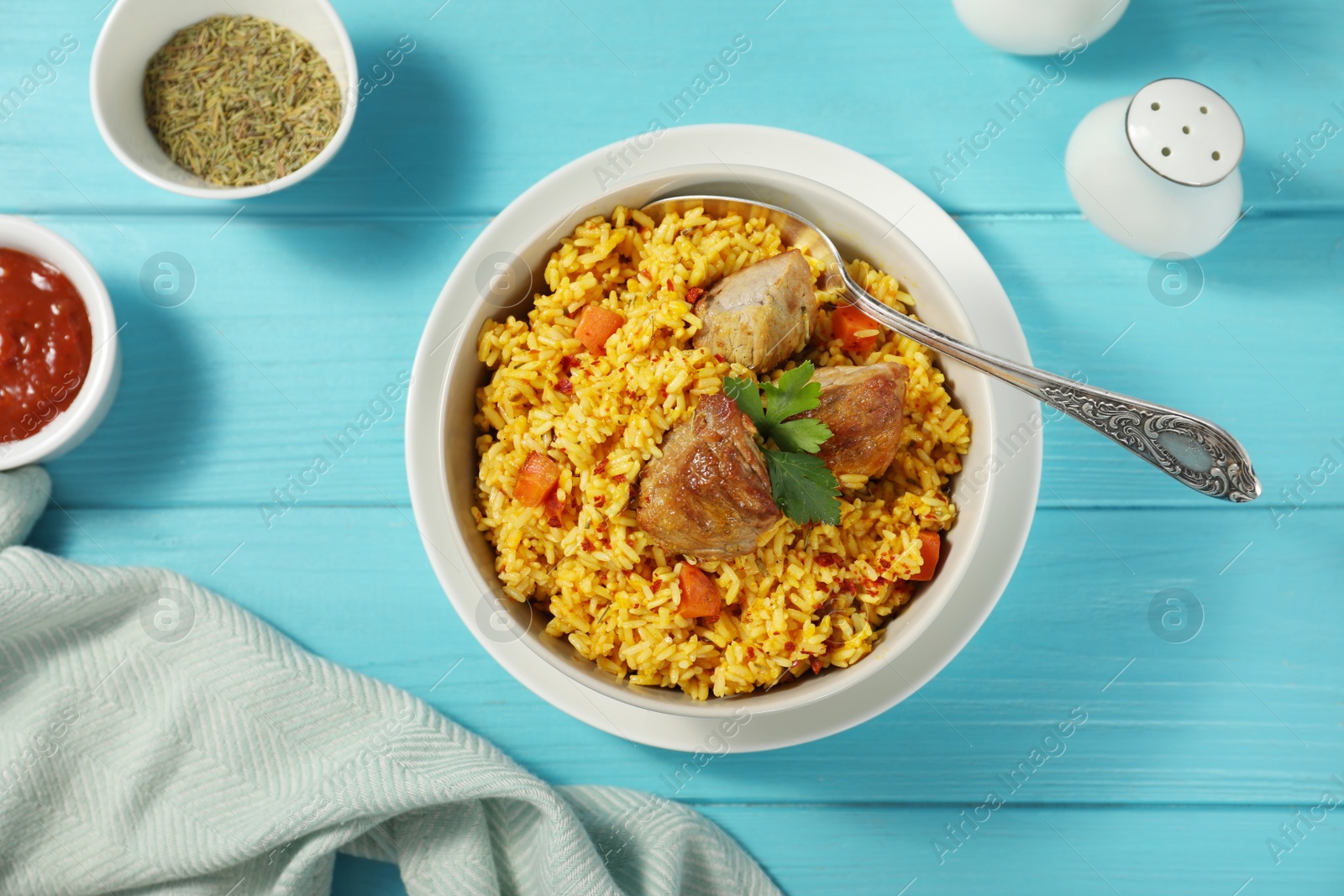 Photo of Delicious rice pilaf served on wooden table, flat lay