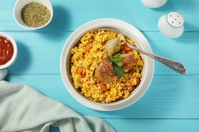 Photo of Delicious rice pilaf served on wooden table, flat lay