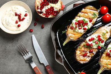 Flat lay composition with grill pan of fried eggplants on gray table