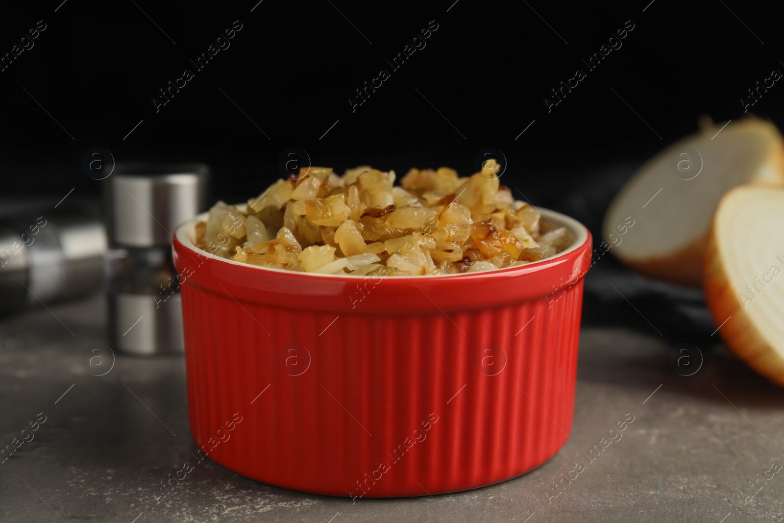 Photo of Tasty fried onion in bowl on grey table