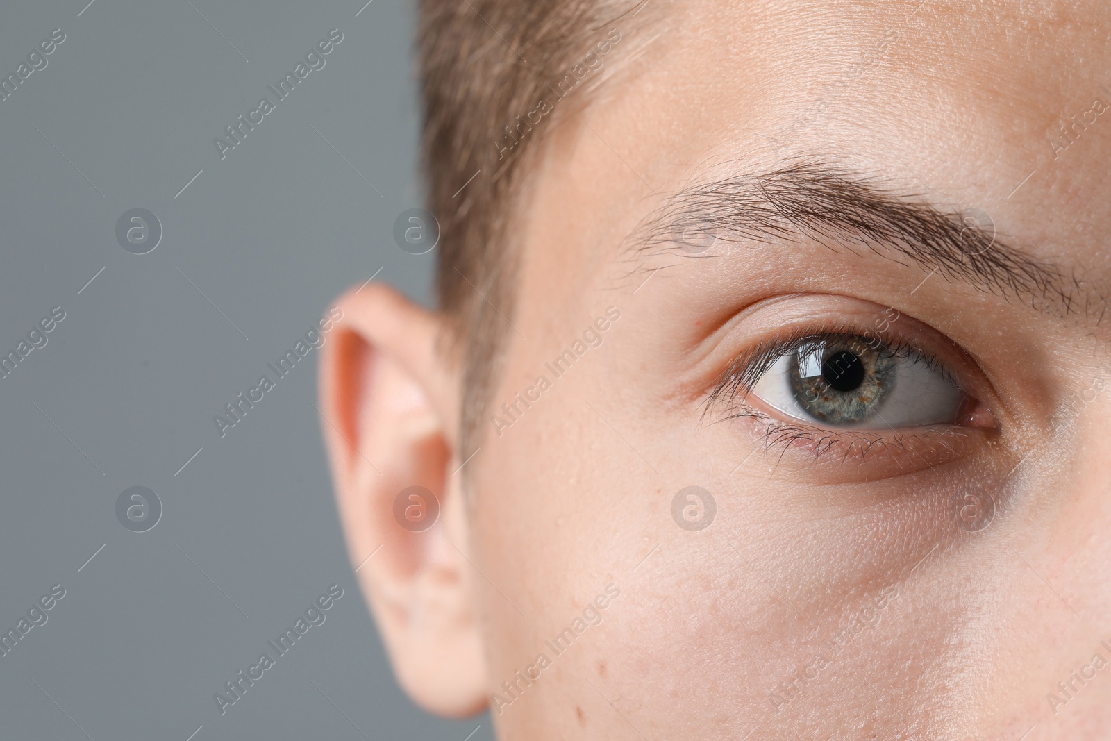 Photo of Perfect vision. Man with beautiful eyes on grey background, closeup. Space for text