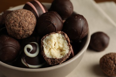 Photo of Bowl with many different delicious chocolate truffles, closeup