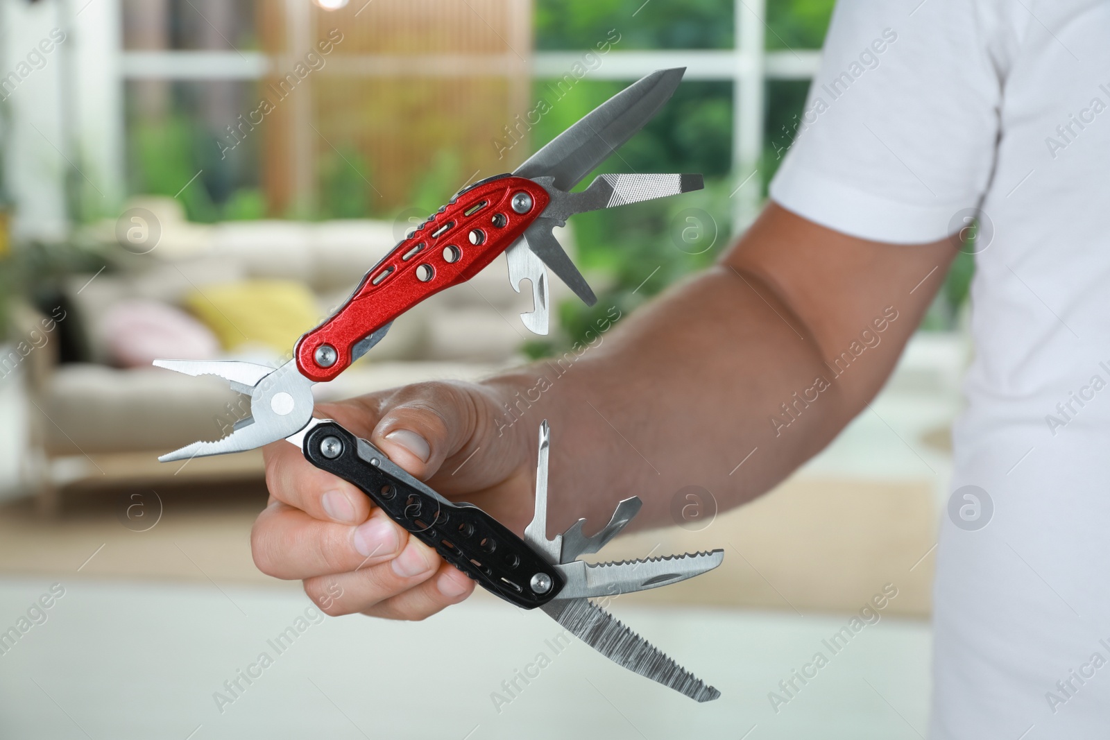 Photo of Man holding compact portable multitool indoors, closeup