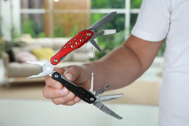 Man holding compact portable multitool indoors, closeup