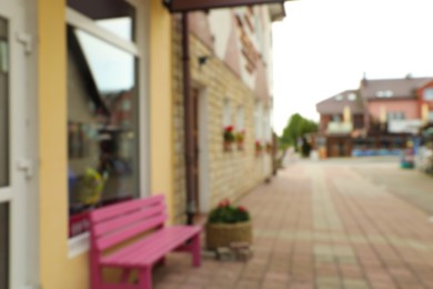 Photo of Blurred view of pink bench near modern store