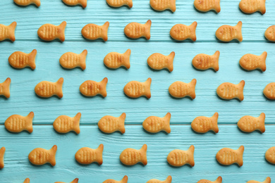 Photo of Delicious goldfish crackers on light blue wooden table, flat lay