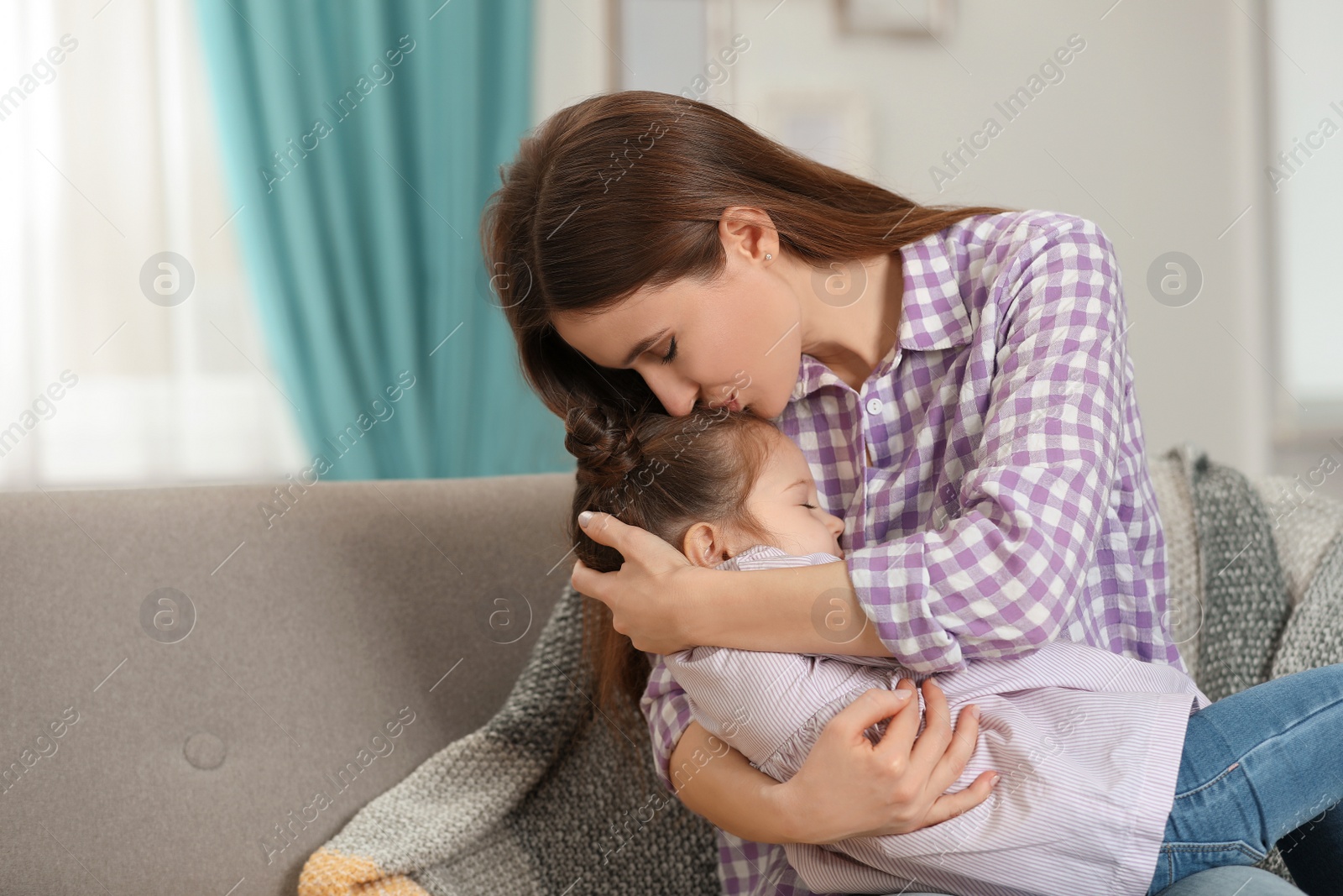 Photo of Young mother with little daughter at home