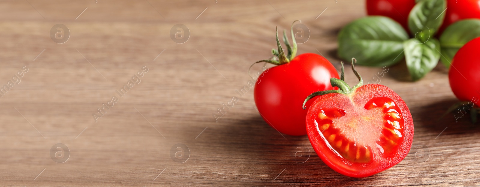 Image of Composition with fresh cherry tomatoes on wooden table, space for text. Banner design 