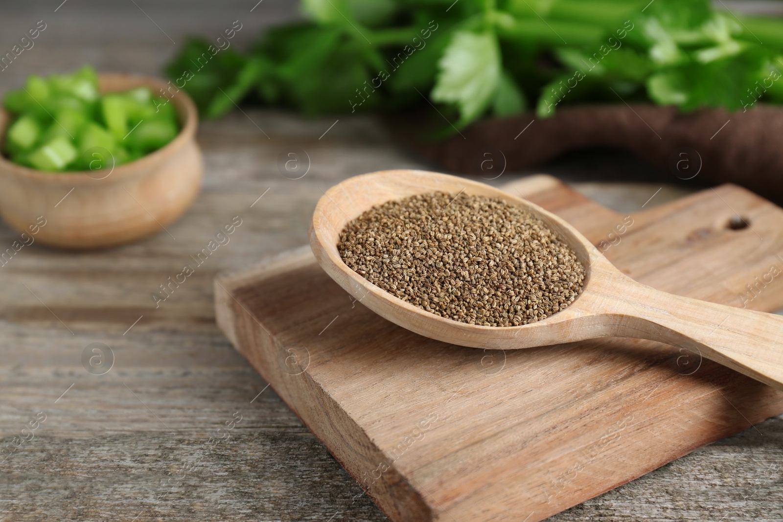 Photo of Spoon of celery seeds on wooden table, closeup. Space for text