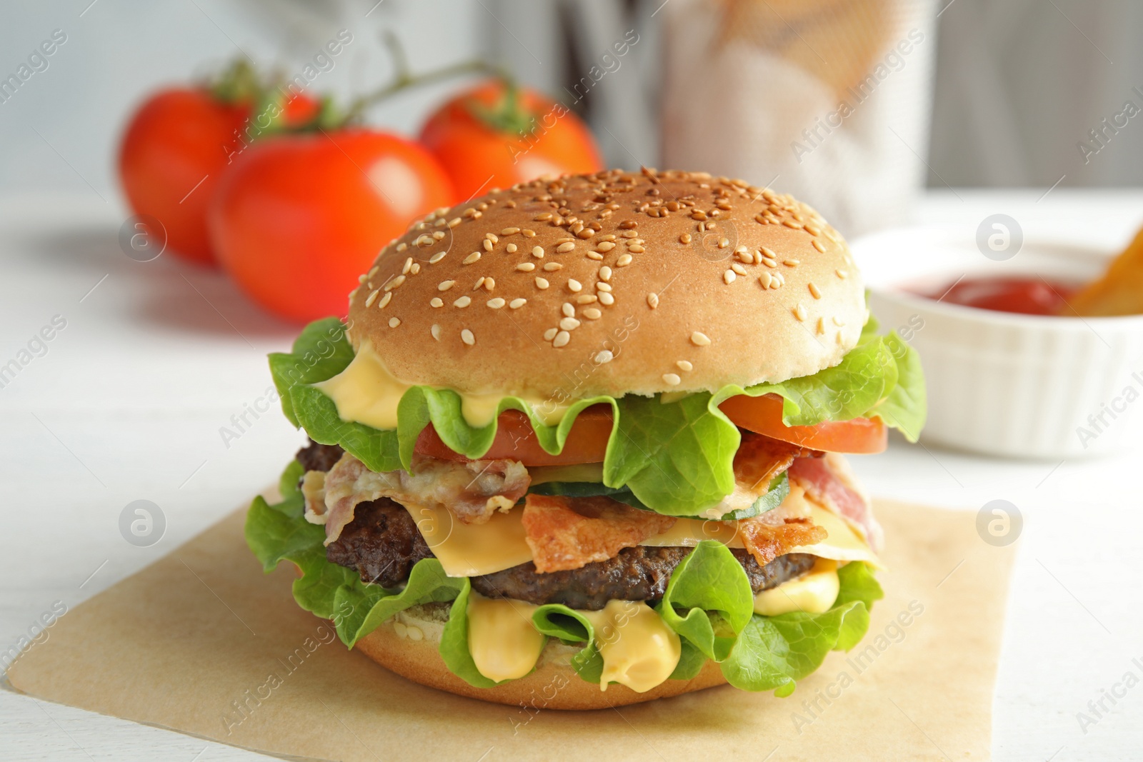 Photo of Tasty burger with bacon served on table