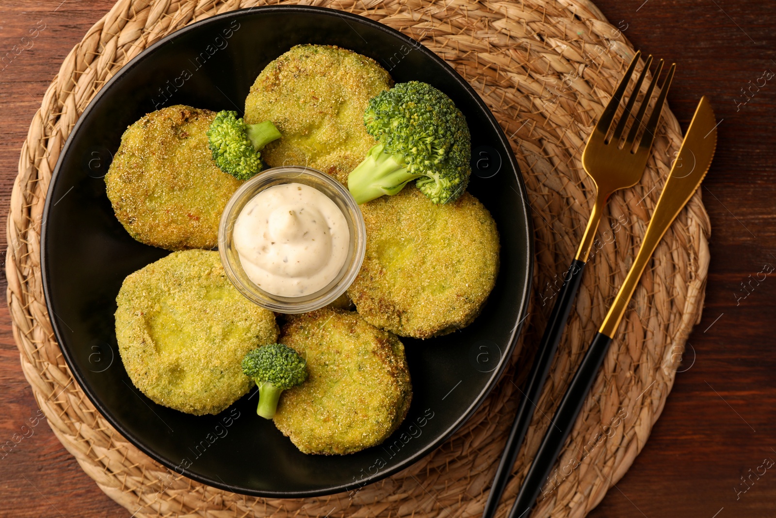 Photo of Tasty vegan cutlets served with sauce on wooden table, top view