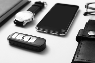 Composition with male accessories and remote car key on white background