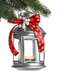 Vintage Christmas lantern with burning candle hanging on fir branch against light background. Space for text