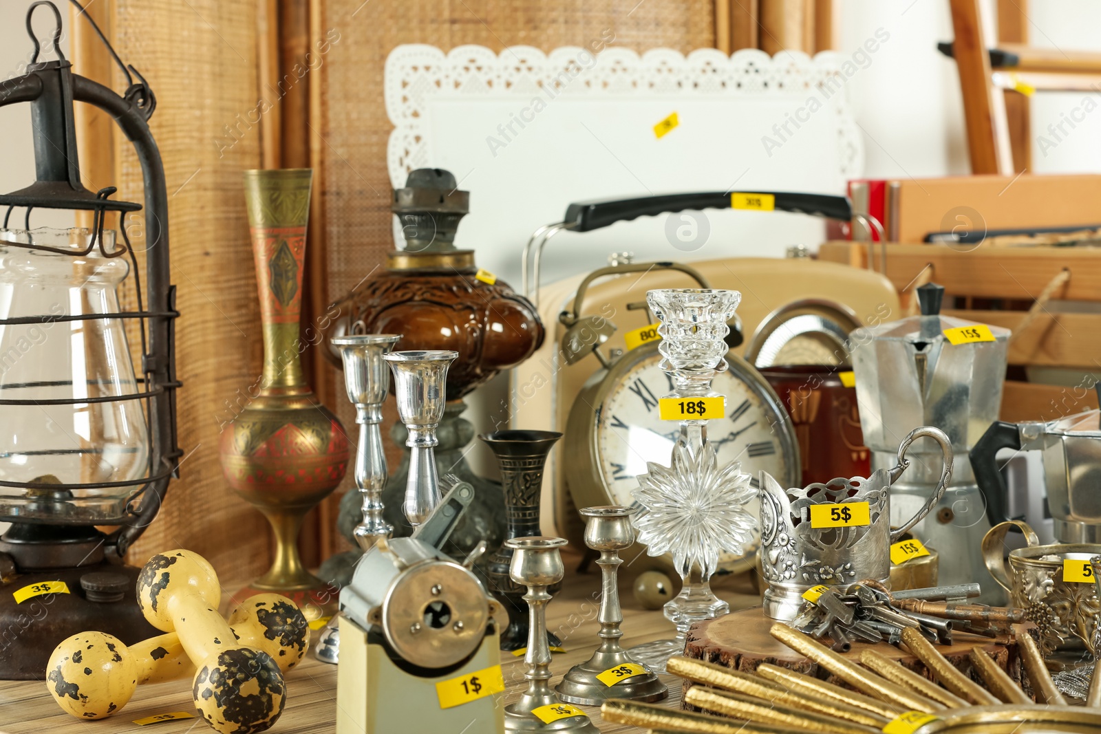 Photo of Many different items on wooden table indoors. Garage sale