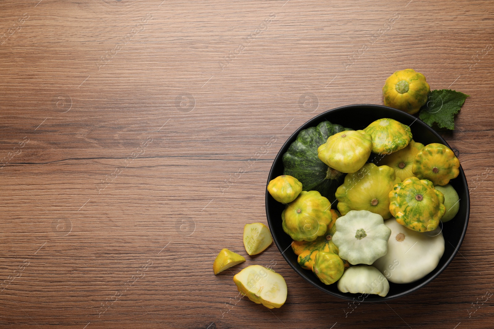 Photo of Fresh ripe pattypan squashes on wooden table, flat lay. Space for text