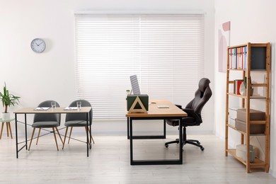 Photo of Director's office with large wooden table and comfortable armchairs. Interior design