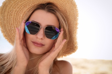Photo of Beautiful woman wearing sunglasses outdoors on sunny day, closeup