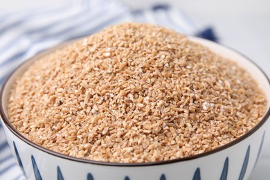 Dry wheat groats in bowl, closeup view