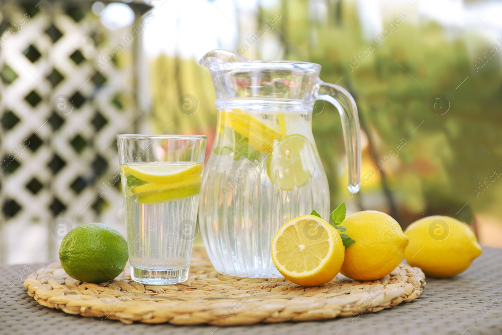 Photo of Water with lemons and limes on table outdoors