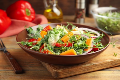 Delicious vegetable salad with microgreen served on wooden table