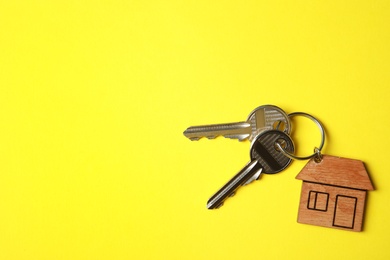 Photo of House keys with trinket on color background, top view. Space for text