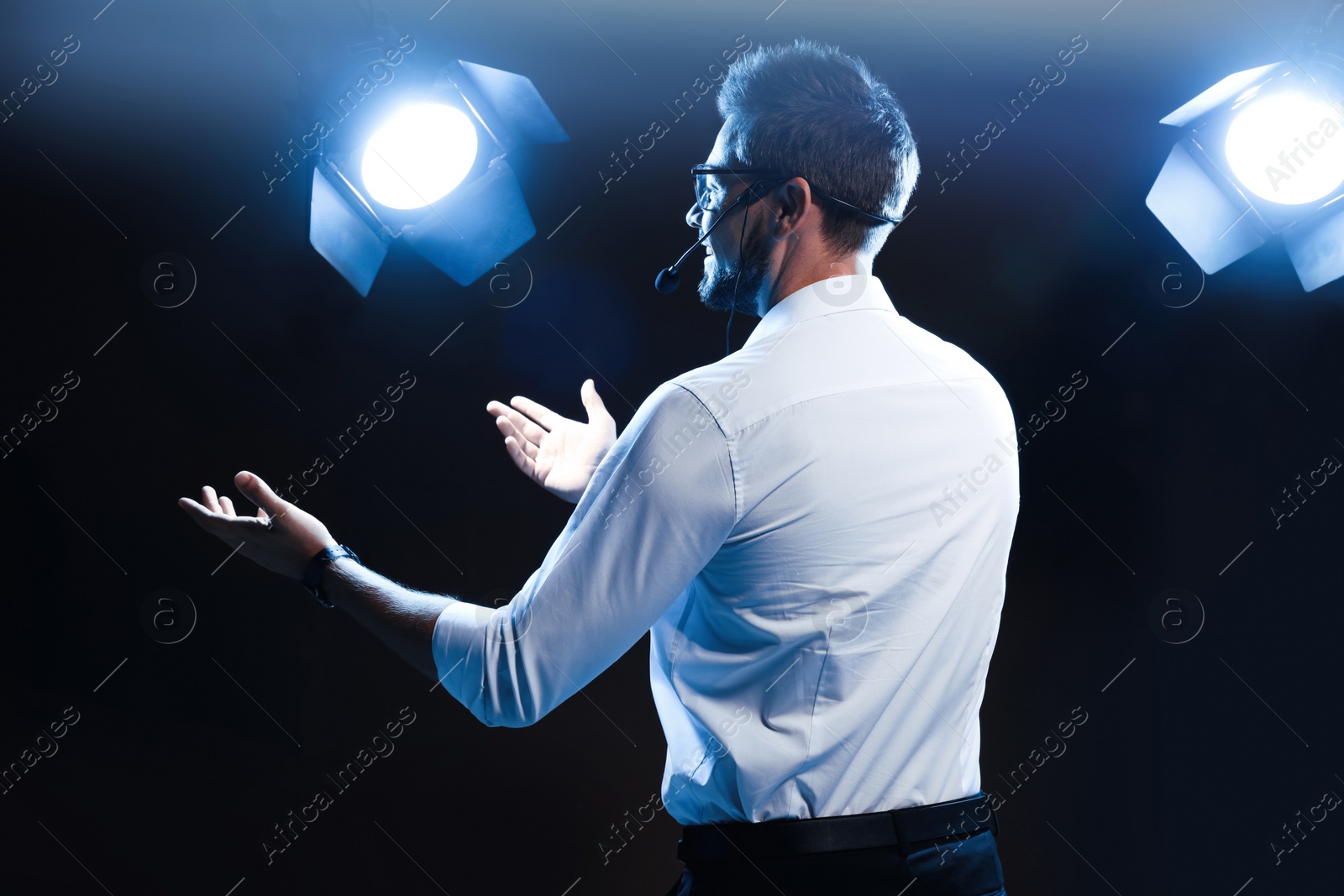 Photo of Motivational speaker with headset performing on stage