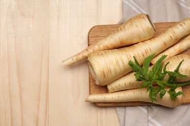 Many fresh ripe parsnips on wooden table, flat lay. Space for text