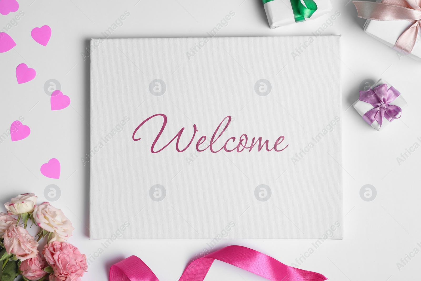 Image of Welcome card. Canvas with word, gift boxes, beautiful roses, pink hearts and ribbon on white background, flat lay