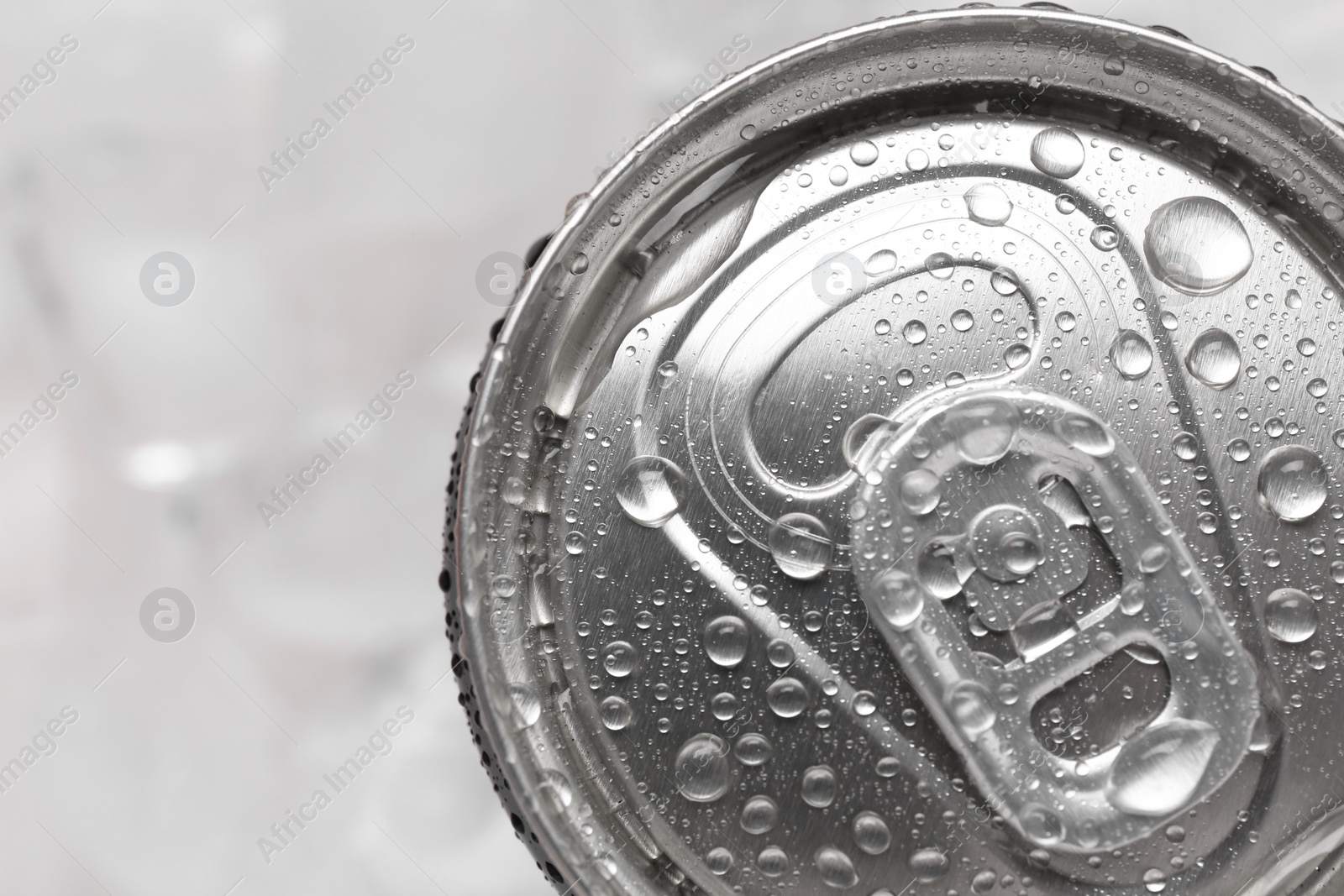 Photo of Energy drink in wet can on light background, top view. Space for text