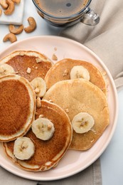 Photo of Tasty pancakes with sliced banana served on table, flat lay