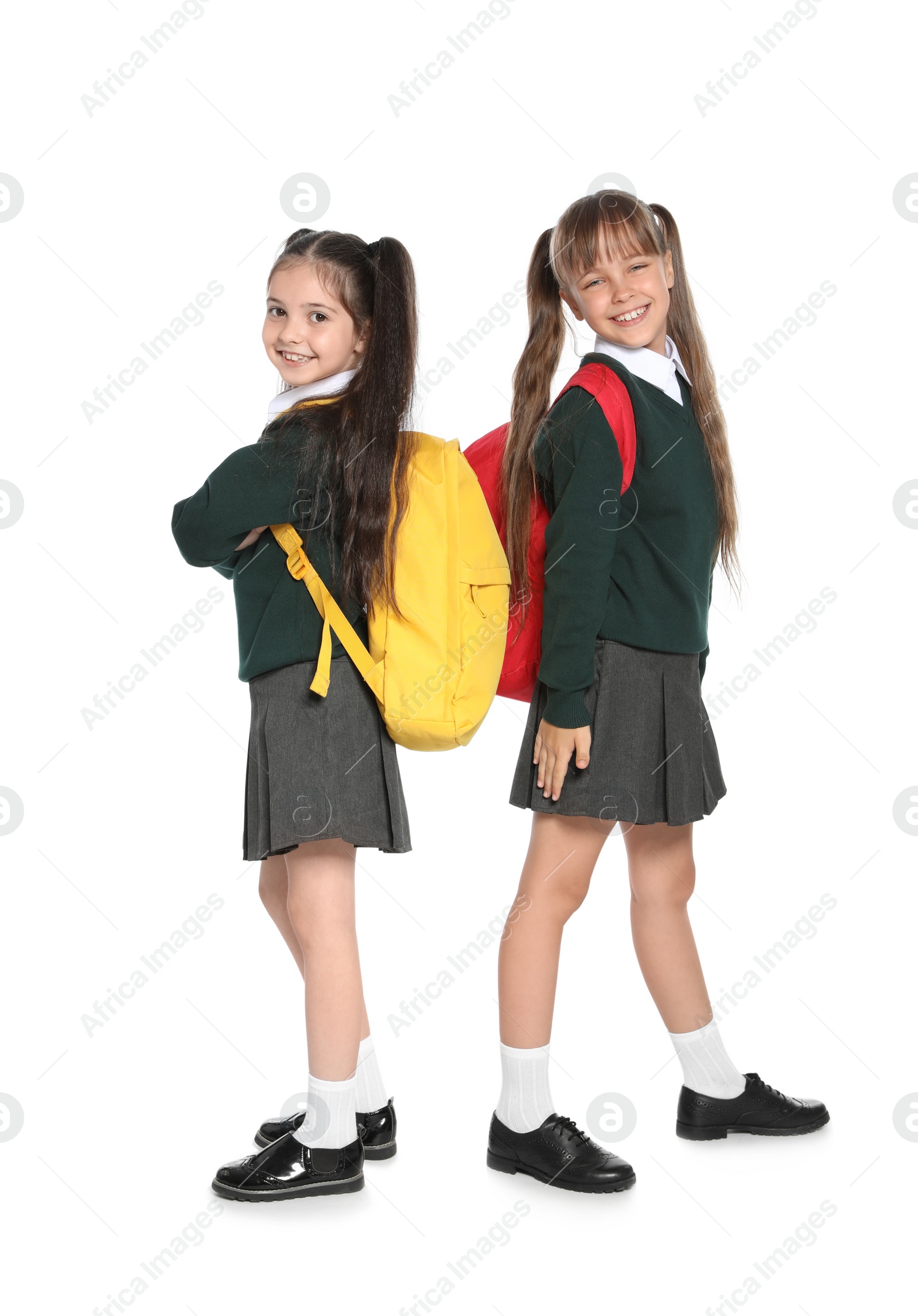 Photo of Little girls in stylish school uniform on white background