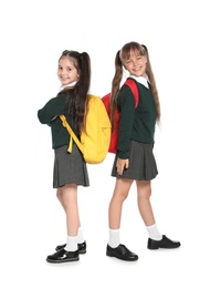 Little girls in stylish school uniform on white background