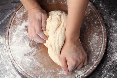 Female baker preparing bread dough at table, top view