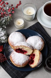 Delicious sweet buns with cherries, cup of tea and decor on table, flat lay