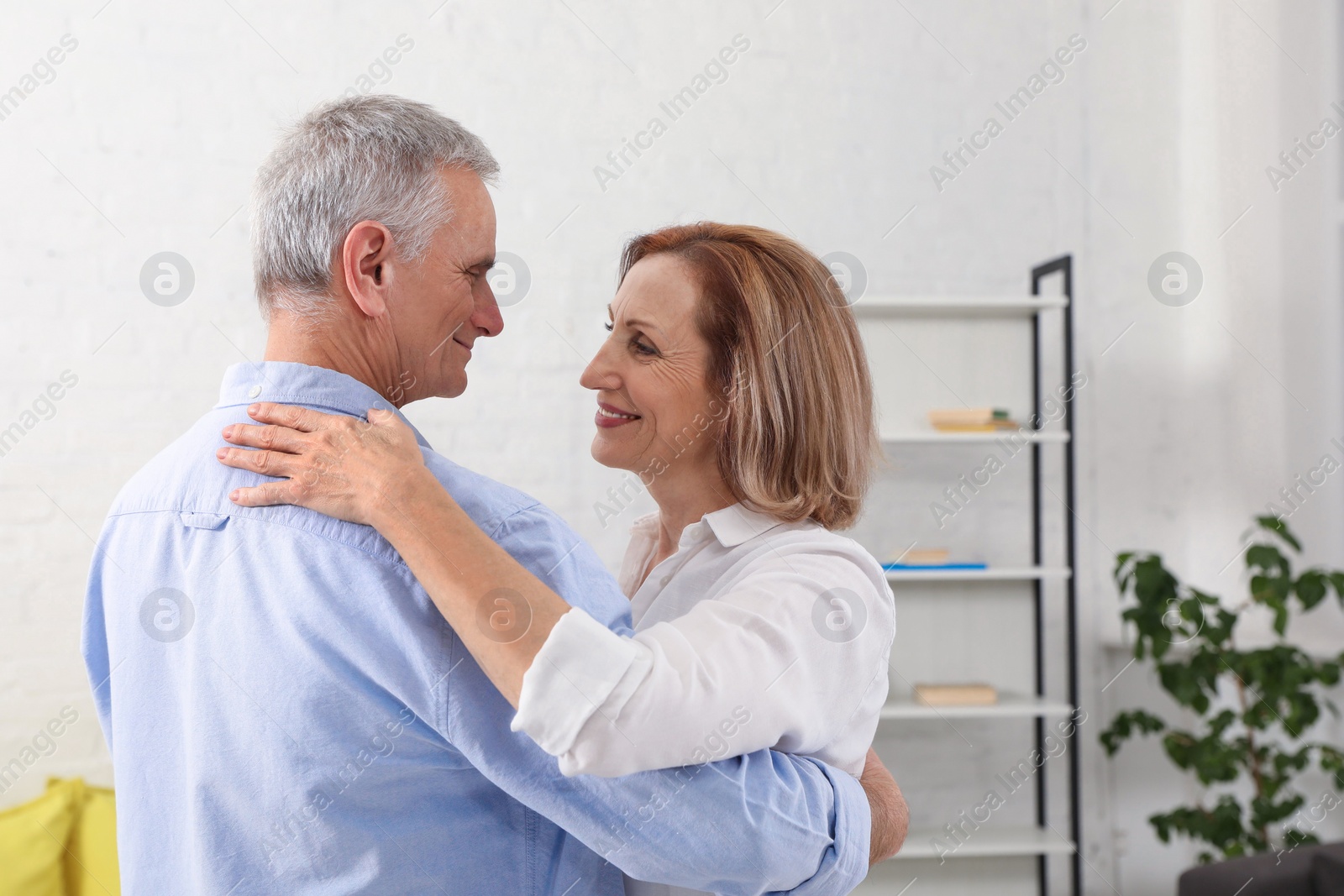 Photo of Happy senior couple dancing together in living room