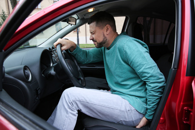 Photo of Man suffering from hemorrhoid pain in car