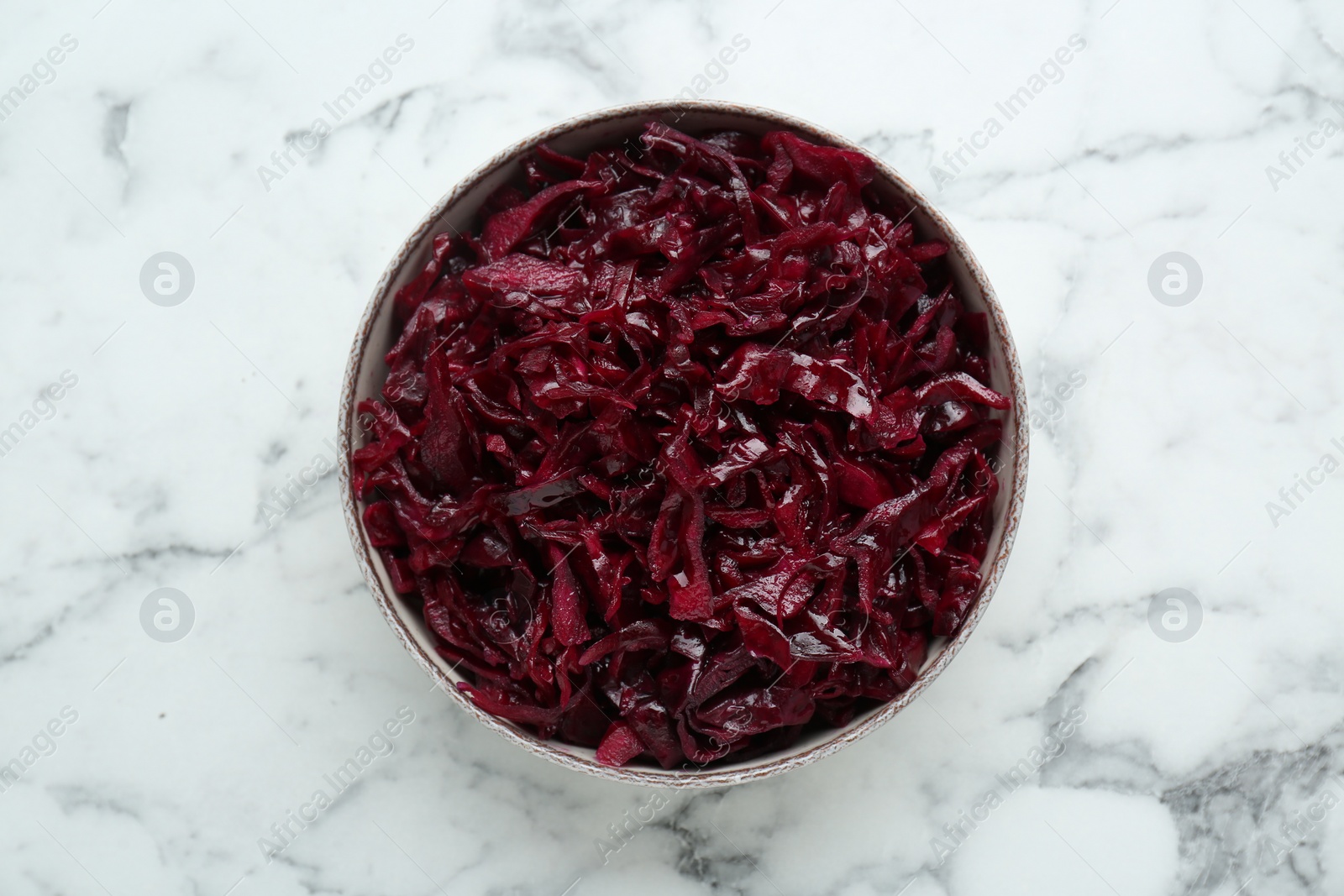 Photo of Tasty red cabbage sauerkraut on white marble table, top view