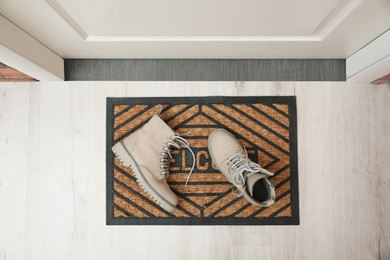 Photo of Stylish shoes on door mat in hall, top view