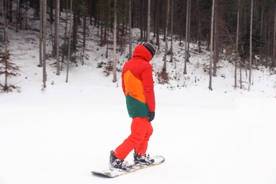 Photo of Snowboarder on slope at resort. Winter vacation