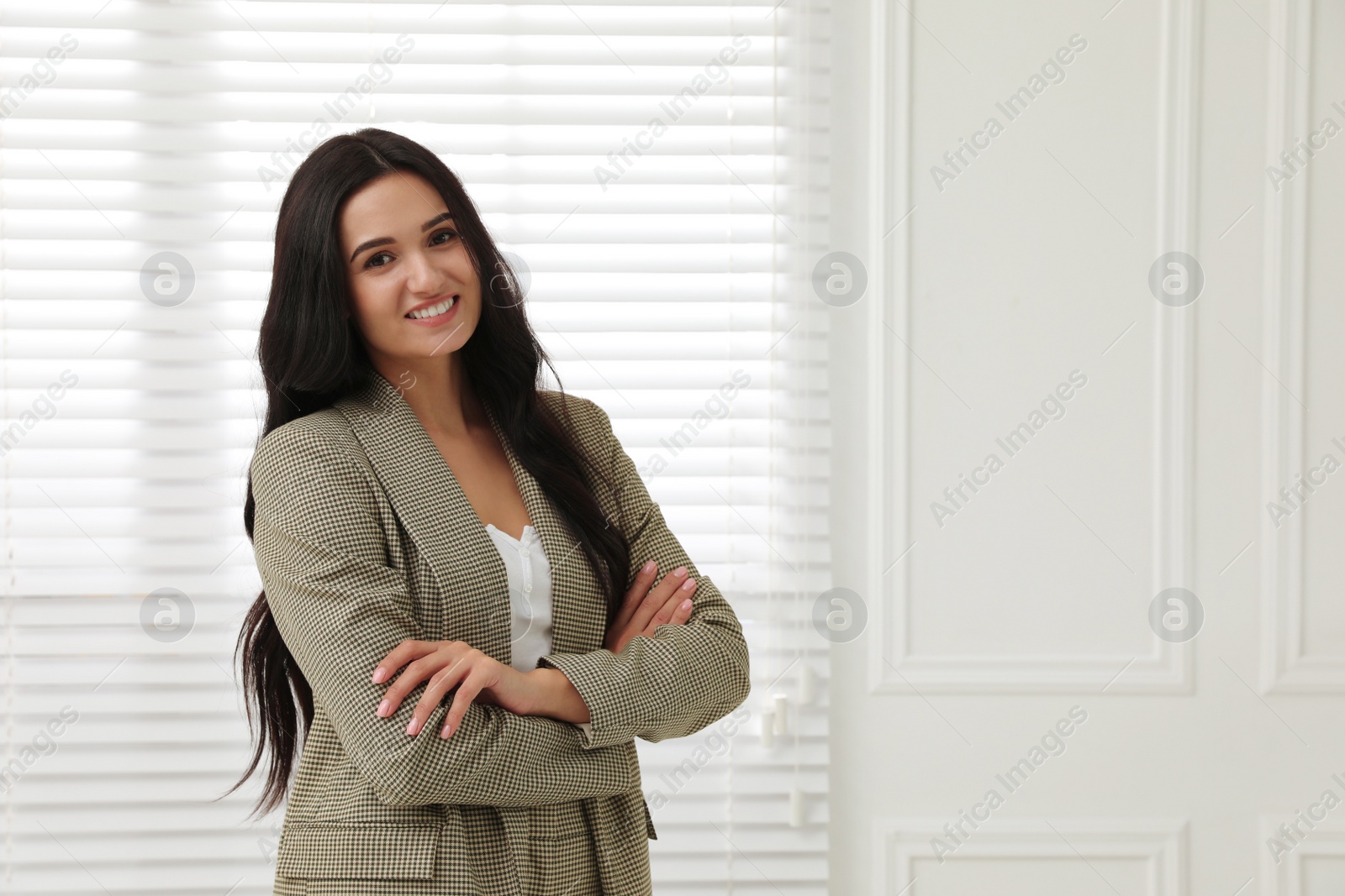 Photo of Beautiful woman in formal suit near window, space for text. Business attire