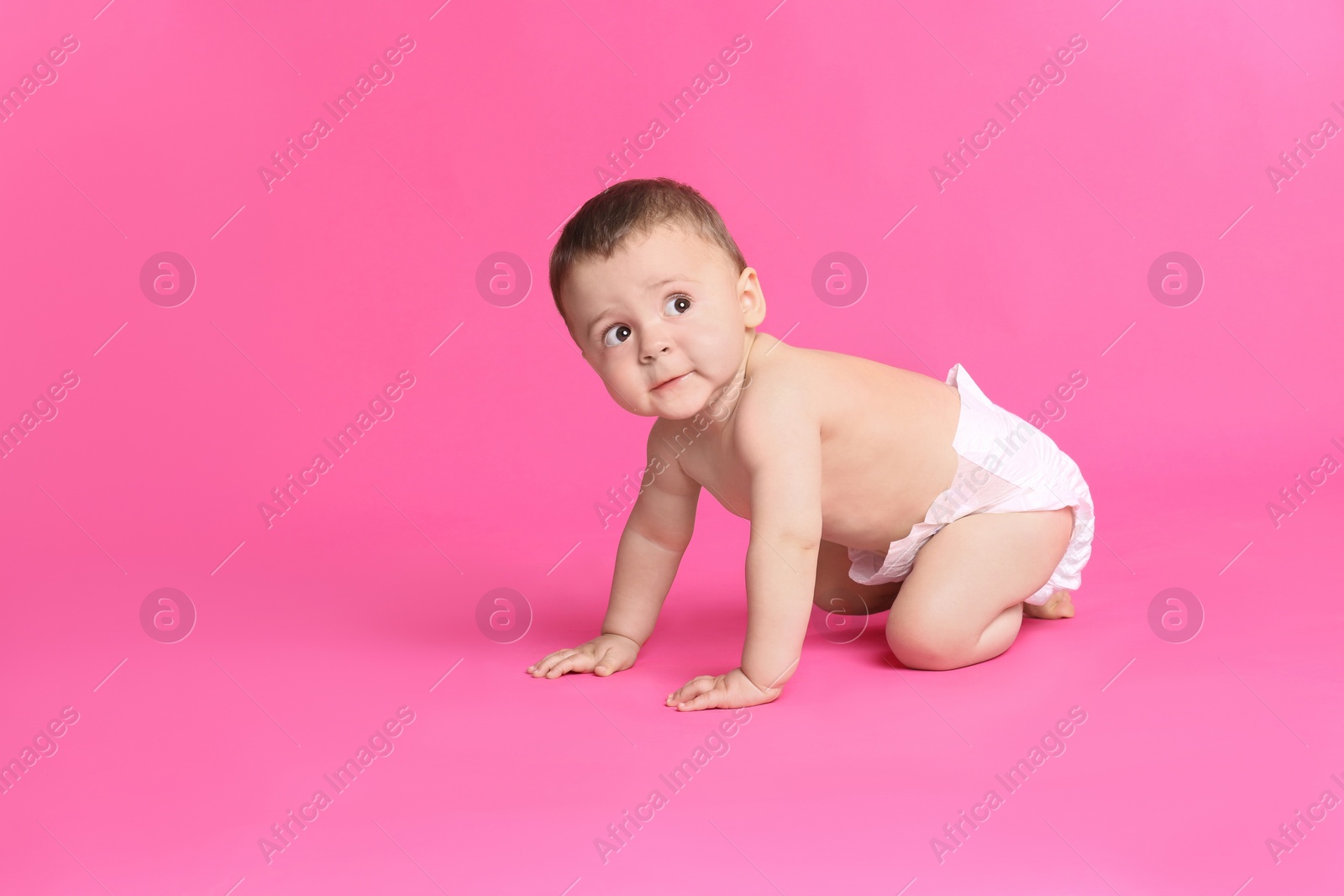 Photo of Cute baby in dry soft diaper crawling on pink background. Space for text