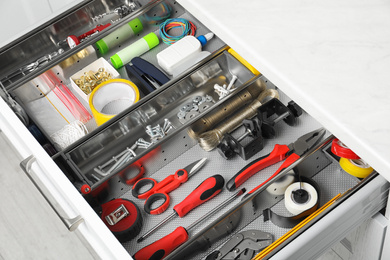 Set of instruments in open desk drawer indoors